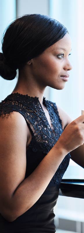 A woman in a professional setting holding a cup of coffee