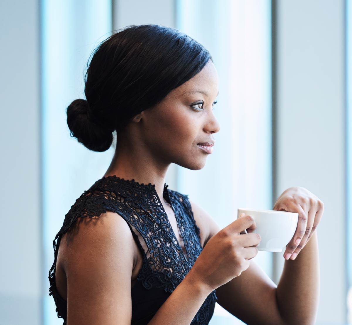 A woman in a professional setting holding a cup of coffee