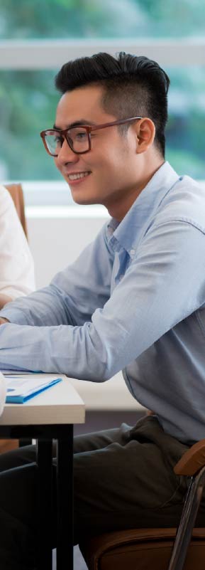 A young professional smiling at a desk.