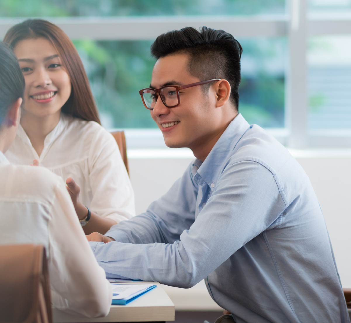 A young professional smiling at a desk.