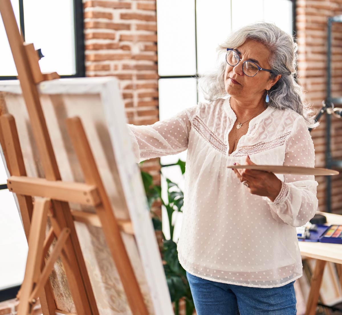 A retirement age woman painting on a canvas