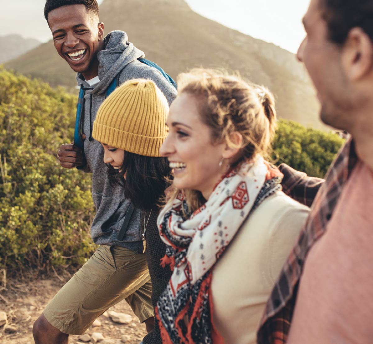 A group of four friends hiking and smiling