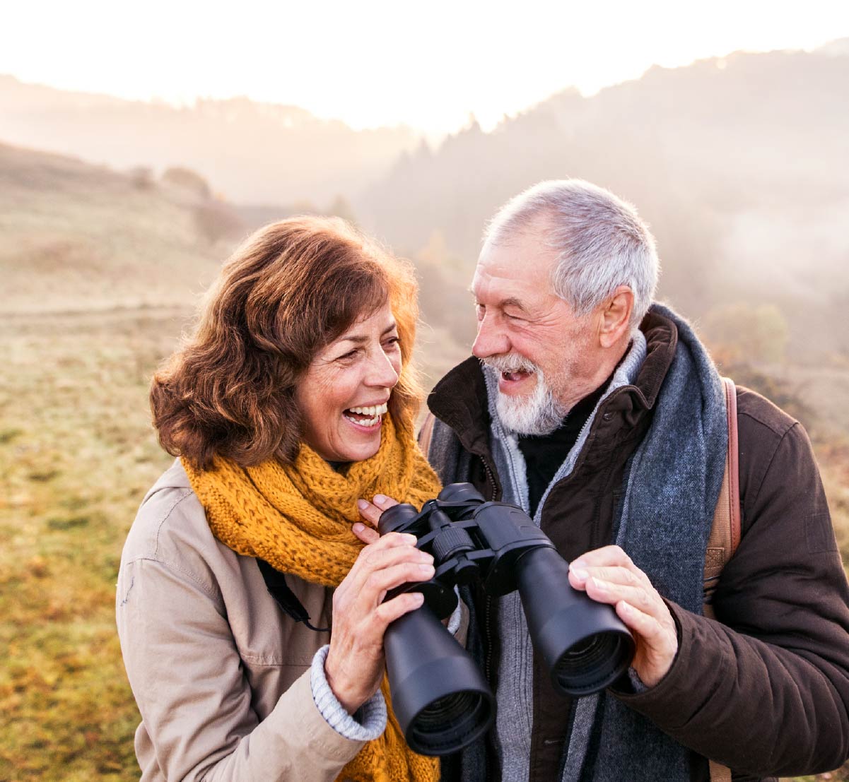 A retirement age couple outside, laughing with each other.