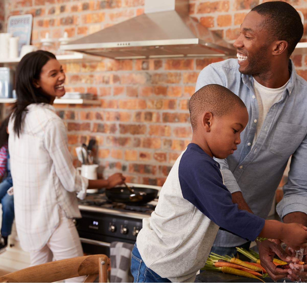 A mom, dad, and child cooking together in a home kitchen