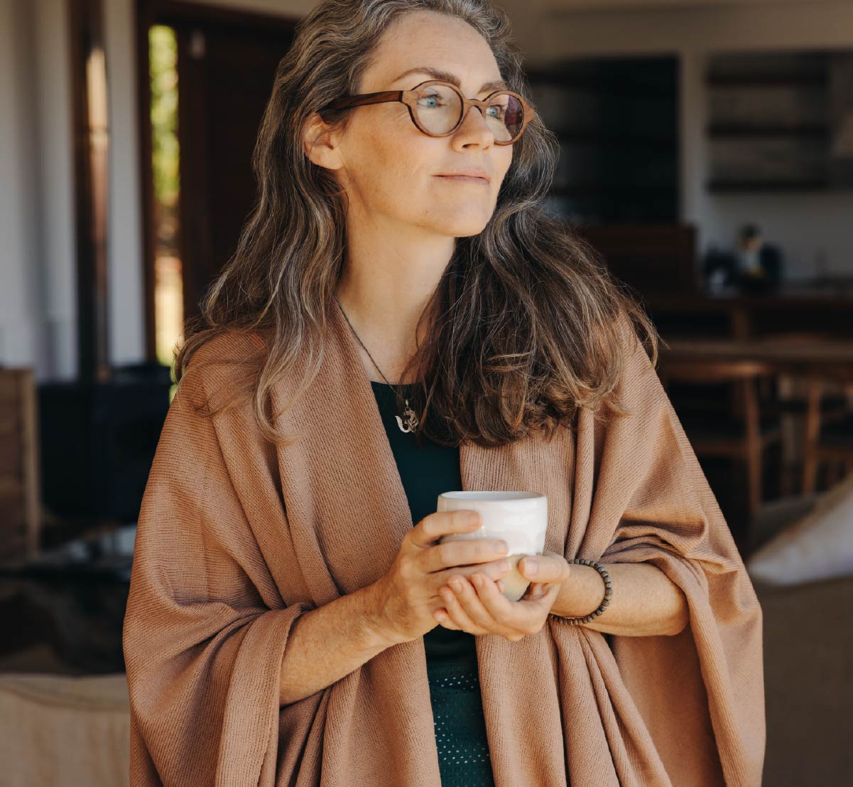 A confident older woman holding a cup of coffee.