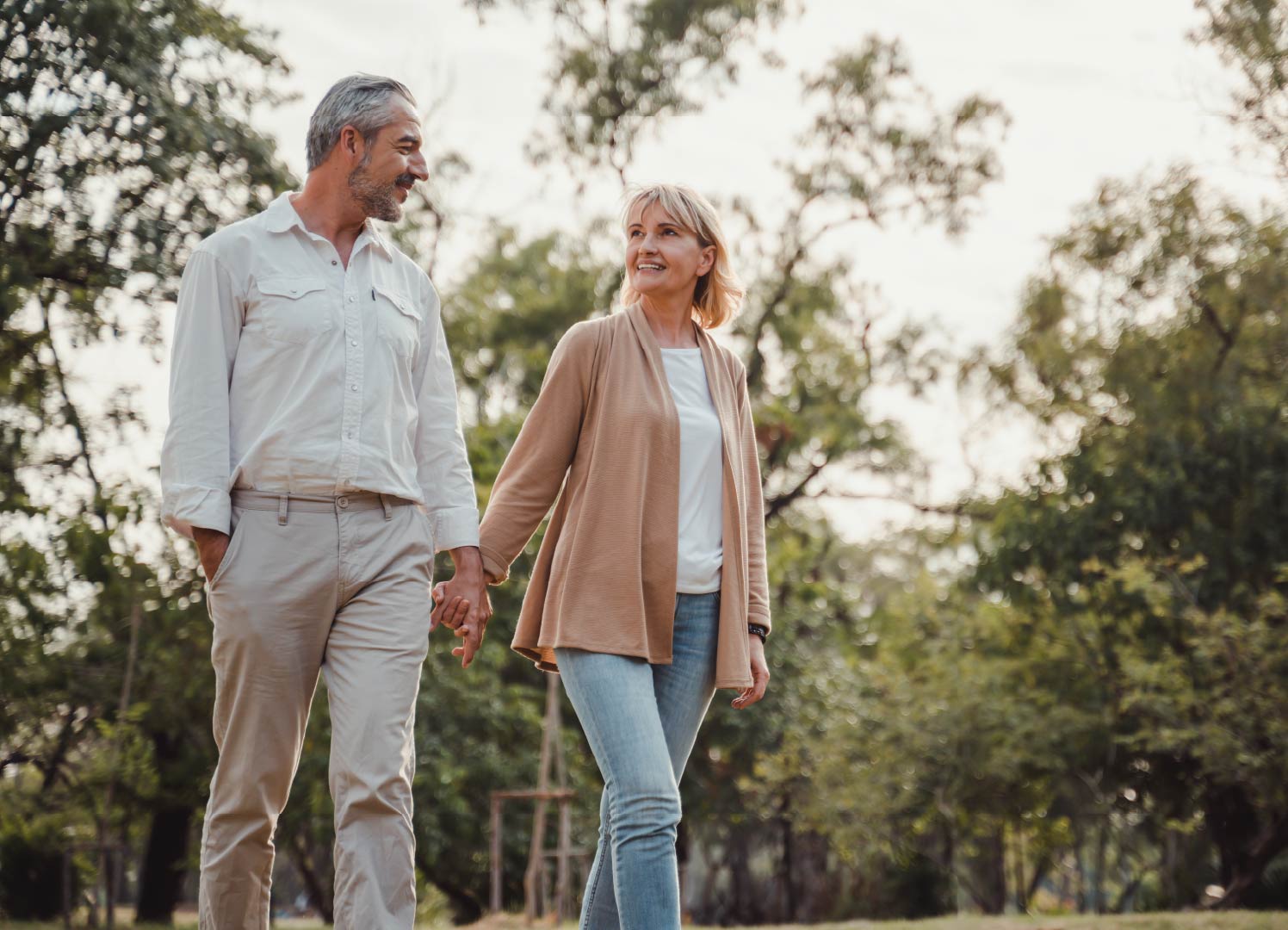 An older couple holding hands and going for a walk