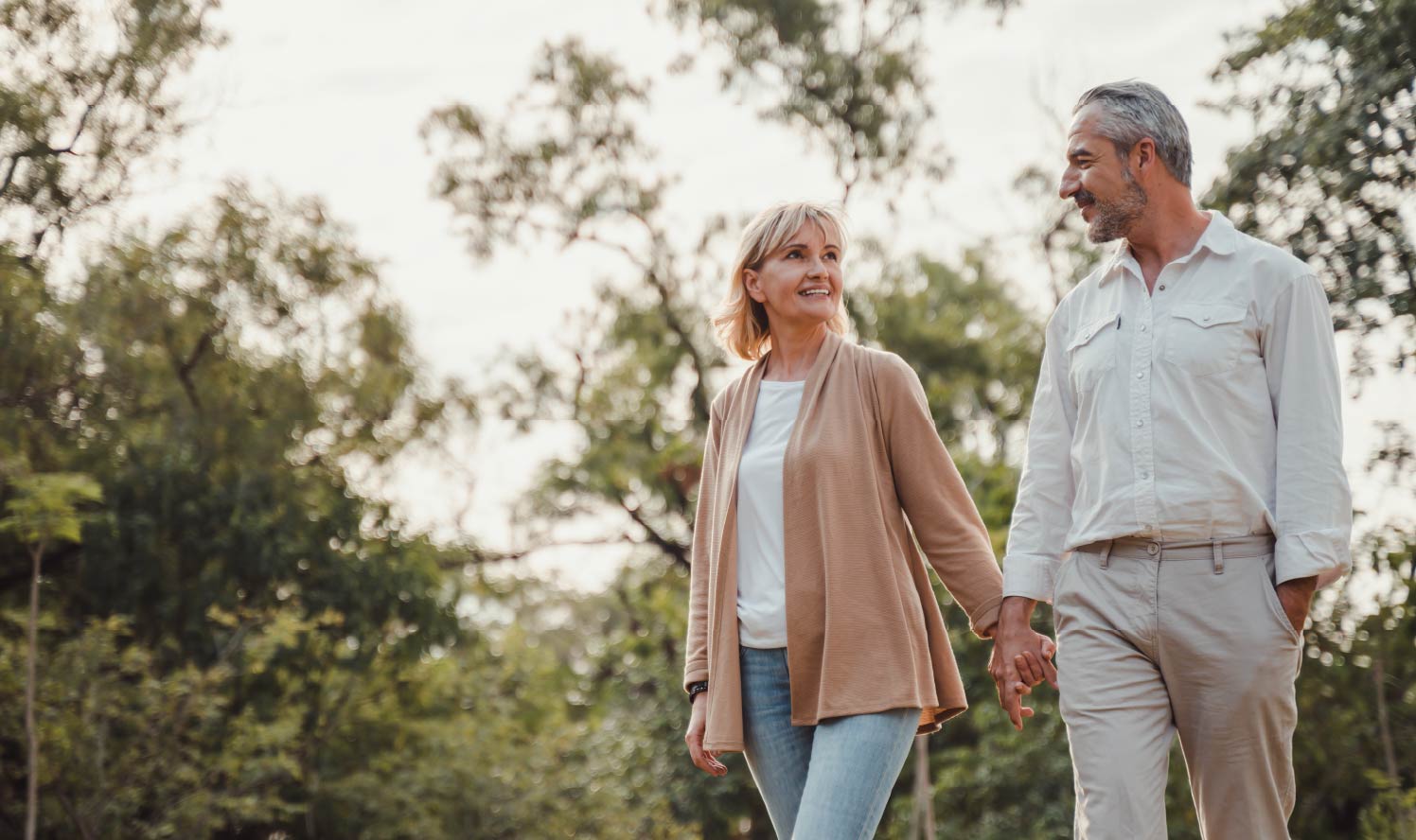 An older couple holding hands and going for a walk