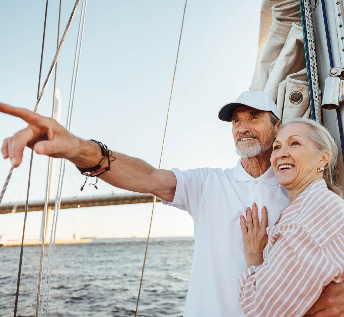 A retirement age couple standing on the deck of a sail boat