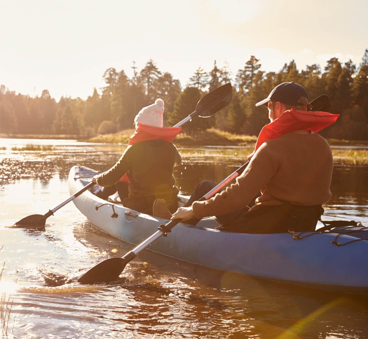 Two people in a double kayak at golden hour