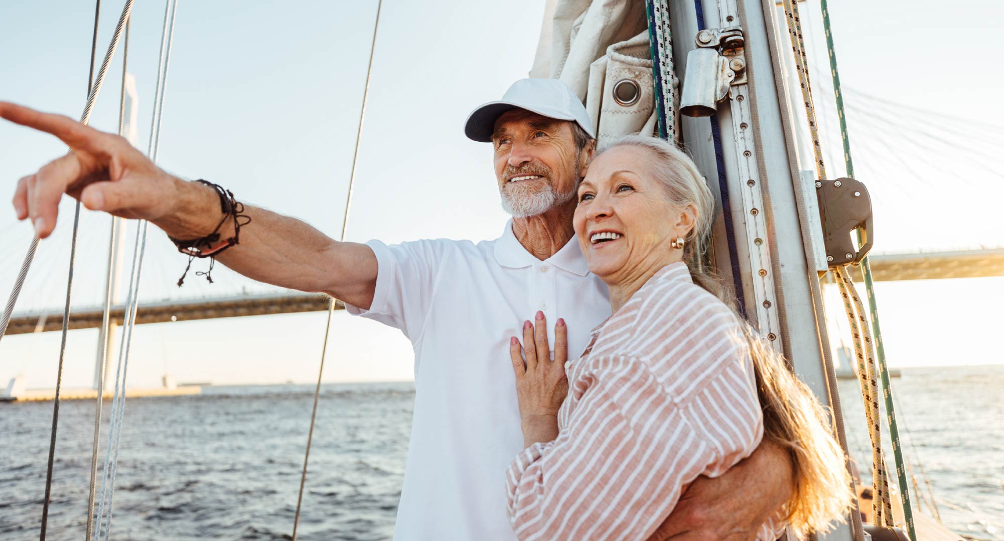 a retirement age couple standing on a sailing boat